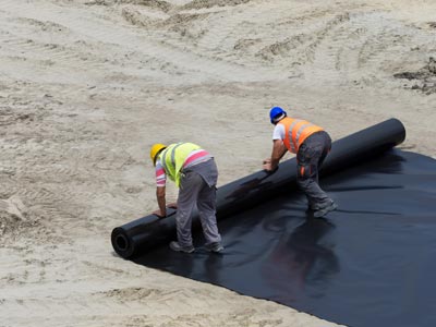 Workers unrolling construction foil